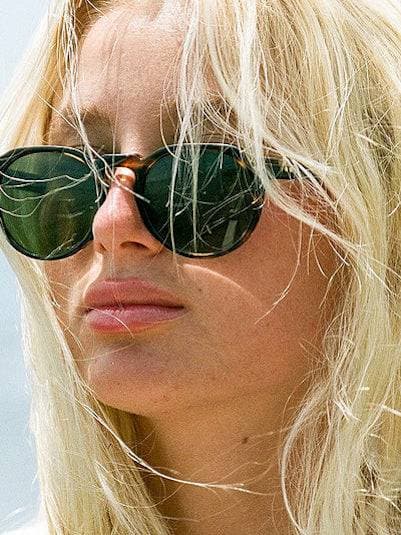 A blonde woman wears dark sunglasses.